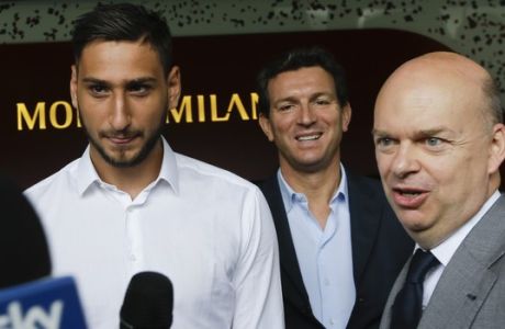 AC Milan goalie Gianluigi Donnarumma, left, is flanked by team CEO Marco Fassone at the 'Casa Milan', AC Milan team headquarters, in Milan Italy, Wednesday, July 12, 2017. AC Milan's teenage goalkeeper Gianluigi Donnarumma has agreed to extend his contract with the Serie A club until 2021. The talented 18-year-old turned down a new deal last month and would have been a free agent at the end of next season. On Tuesday, Milan announced it had reached an agreement with Donnarumma, saying he would sign a new four-year contract the following morning. (AP Photo/Luca Bruno)