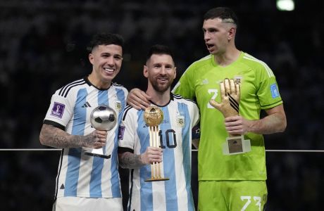 Argentina's Enzo Fernandez, Lionel Messi and goalkeeper Emiliano Martinez, from left to right, pose with their individual awards at the end of the World Cup final soccer match between Argentina and France at the Lusail Stadium in Lusail, Qatar, Sunday, Dec. 18, 2022. Argentina won 4-2 in a penalty shootout after the match ended tied 3-3. (AP Photo/Martin Meissner)