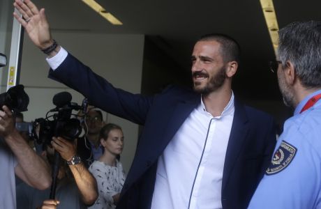 Italy defender Leonardo Bonucci waves to fans as he walks off AC Milan's headquarters, in Milan, Italy, Friday, July 14, 2017. Bonucci is close to completing a transfer from Juventus to rival AC Milan that could signal a shift in the balance of power in Serie A. (AP Photo/Luca Bruno)