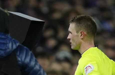 Referee Thomas Bramall checks the VAR screen during the English FA Cup third round soccer match between Leeds United and Cardiff City at Elland Road Stadium in Leeds, England, Wednesday, Jan. 18, 2023. (AP Photo/Jon Super)