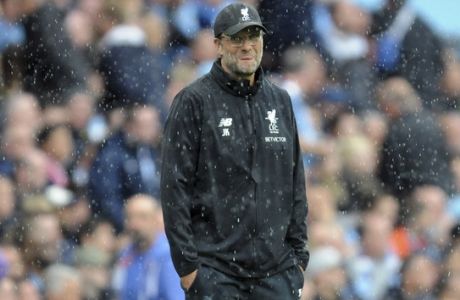 Liverpool's coach Juergen Klopp walks on the pitch during heavy rainfall after the English Premier League soccer match between Manchester City and Liverpool at the Etihad Stadium in Manchester, England, Saturday, Sept. 9, 2017. Manchester defeated Liverpool by 5-0. (AP Photo/Rui Vieira)