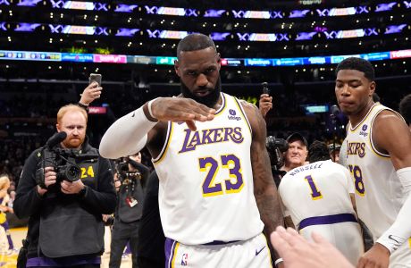 Los Angeles Lakers forward LeBron James salutes public address announcer Lawrence Tanter prior to an NBA basketball game against the Denver Nuggets Saturday, March 2, 2024, in Los Angeles. (AP Photo/Mark J. Terrill)