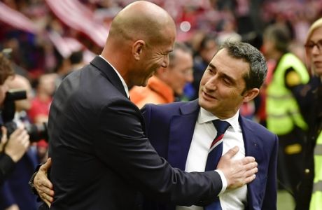 FILE - In this March 18, 2017 file photo, Athletic Bilbao's head manager Ernesto Valverde, center right and Real Madrid's head coach Zinedine Zidane greet each other before the start of the Spanish La Liga soccer match between Real Madrid and Athletic Bilbao, at San Mames stadium, in Bilbao, northern Spain. Athletic Bilbao said on Wednesday May 24 that Valverde will not remain as the team's coach next season, clearing the way for his expected move to Barcelona. (AP Photo/Alvaro Barrientos, File)