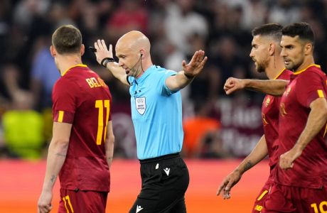 Referee Anthony Taylor signals no penalty for Sevilla after checking the VAR during the Europa League final soccer match between Sevilla and Roma, at the Puskas Arena in Budapest, Hungary, Wednesday, May 31, 2023. (AP Photo/Petr David Josek)