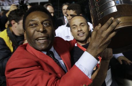 FILE - Former Brazilian soccer player Pele, left, celebrates at the end of the Copa Libertadores soccer final match between Brazil's Santos and Uruguay's Penarol in Sao Paulo, Brazil, June 22, 2011. Santos won 2-1. Pelé, the Brazilian king of soccer who won a record three World Cups and became one of the most commanding sports figures of the last century, died in Sao Paulo on Thursday, Dec. 29, 2022. He was 82. (AP Photo/Andre Penner, File)