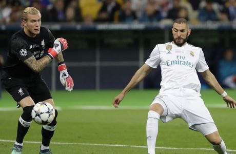Real Madrid's Karim Benzema, right, scores against Liverpool goalkeeper Loris Karius during the Champions League Final soccer match between Real Madrid and Liverpool at the Olimpiyskiy Stadium in Kiev, Ukraine, Saturday, May 26, 2018. (AP Photo/Sergei Grits)