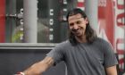 AC Milan's Zlatan Ibrahimovic laughs as he stands near the bench during a Serie A soccer match between AC Milan and Monza, at the San Siro stadium in Milan, Italy, Saturday, Oct. 22, 2022. (AP Photo/Luca Bruno)