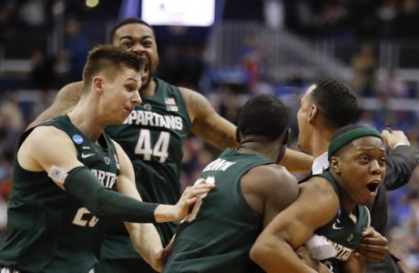 Michigan State guard Cassius Winston, right, celebrates with teammates Matt McQuaid (20), Nick Ward (44) and Gabe Brown (13) after defeating Duke in an NCAA men's East Regional final college basketball game in Washington, Sunday, March 31, 2019. (AP Photo/Patrick Semansky)