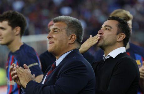 Barcelona club President Joan Laporta, centre and head coach Xavi Hernandez applaud and blow kisses to the fans at the end of a Spanish La Liga soccer match between Barcelona and Mallorca at the Camp Nou stadium in Barcelona, Spain, Sunday, May 28, 2023. (AP Photo/Joan Monfort)