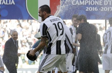 Juventus' Leonardo Bonucci sprays sparkling wine as Juventus players celebrate winning an unprecedented sixth consecutive Italian title, at the end of the Serie A soccer match between Juventus and Crotone at the Juventus stadium, in Turin, Italy, Sunday, May 21, 2017. (AP Photo/Antonio Calanni)