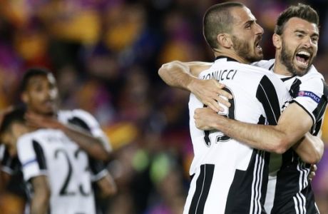 FILE - In this Wednesday, April 19, 2017. file photo, Juventus' Leonardo Bonucci, left, celebrates with teammate Andrea Barzagli, right, during the Champions League quarterfinal second leg soccer match between Barcelona and Juventus at Camp Nou stadium in Barcelona, Spain. Juventus keeps on breaking records. And it set another one on Sunday when it clinched an unprecedented sixth successive Serie A title, with one game to spare, following a victory over Crotone. It is the first time since Serie A was founded in 1929 that a club has won six straight titles. (AP Photo/Manu Fernandez, File)