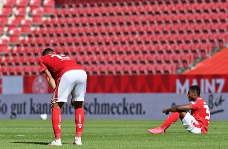 Hoffenheim's Robert Skov, left, in action with Mainz's Pierre Malong during the German Bundesliga soccer match between Mainz and Hoffenheim at the Opel Arena stadium in Mainz, Germany, Saturday, May 30, 2020. Because of the coronavirus outbreak all soccer matches of the German Bundesliga take place without spectators. (Sascha Steinbach/pool photo via AP)