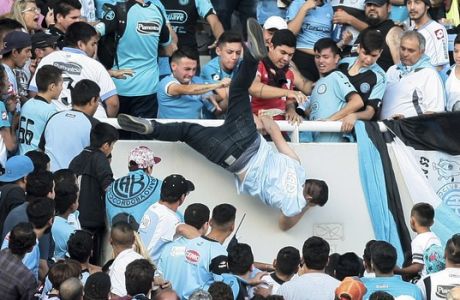 ALTERNATIVE CROP TO XNP101 - In this Saturday, April 15, 2017 photo, Emanuel Balbo is thrown from the stands by other fans during a match between Belgrano and Talleres, in Cordoba, Argentina. Balbo has been declared brain dead after he was chased down the terraces of a stadium and thrown from the bleachers. Balbo's father says his son was attacked by a mob after he faced off with a man that Balbo blamed for killing his brother. (AP Photo/Alvaro Martin Corral)