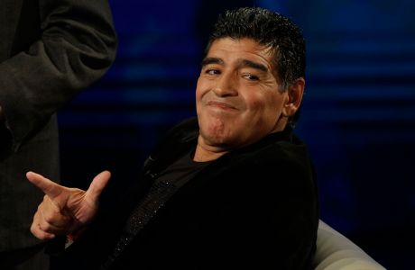 Argentine's former soccer Diego Armando Maradona watches as he attends the Italian TV state program 'Che tempo che fa', in Milan, Italy, Sunday, Oct. 20, 2013. Italy's tax collection agency says it has formally notified Diego Maradona that it will begin procedures to freeze his assets in Italy to pay off his tax debt of $53 million. Equitalia confirmed news reports Friday saying its agents had served Maradona with the notification in his Milan hotel room, and that he signed the documentation. The Argentine great is in Italy to promote a video series on his life and watched his former club Napoli play Roma on Friday. (AP Photo/Luca Bruno)