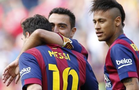 FC Barcelona's Lionel Messi, left, is congratulated by teammate Xavi Hernandez, second right, after scoring against Deportivo Coruna during a Spanish La Liga soccer match at the Camp Nou stadium in Barcelona, Spain, Saturday, May 23, 2015. (AP Photo/Manu Fernandez)