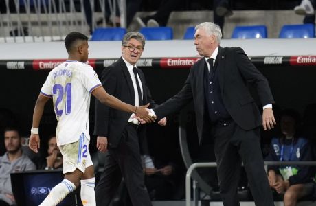 Real Madrid's head coach Carlo Ancelotti, right, shakes hands with Real Madrid's Rodrygo during a Spanish La Liga soccer match between Real Madrid and Levante at the Santiago Bernabeu stadium in Madrid, Thursday, May 12, 2022. (AP Photo/Manu Fernandez)