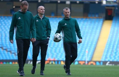 Referee Björn Kuipers, right and other officials inspect the pitch prior to the  Champions League group C soccer match at the Etihad Stadium between Manchester City and Borussia Moenchengladbach in Manchester, England, Wednesday, Sept. 14, 2016. The match was rearranged from Tuesday due to adverse weather conditions in Manchester.  (AP Photo/Dave Thompson)
