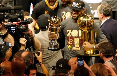 epa05378703 Cleveland Cavaliers forward LeBron James poses with the MVP trophy and the NBA Championship trophy after defeating the Golden State Warriors in NBA Finals game seven at Oracle Arena in Oakland, California, USA, 19 June 2016. The Cavaliers defeated the Warriors to win the NBA Finals Champions.  EPA/JOHN G. MABANGLO CORBIS OUT ORG XMIT: JGM03