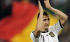 Germany's scorer Miroslav Klose celebrates in front of a German flag after the Euro 2012 Group A qualifying soccer match between Germany and Azerbaijan in Cologne, Germany, Tuesday Sept. 7, 2010. Germany won the match with 6-1. (AP Photo/Martin Meissner)