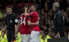 Manchester United's interim manager Ryan Giggs, right, embraces teammate Tom Lawrence as he takes to the pitch as a substitute during his team's English Premier League soccer match against Hull at Old Trafford Stadium, Manchester, England, Tuesday May 6, 2014. (AP Photo/Jon Super)  