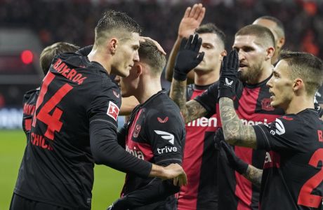 Leverkusen's Patrik Schick, left, celebrates with his teammates after he scored the first of his three goals during the German Bundesliga soccer match between Bayer Leverkusen and VfL Bochum at the BayArena in Leverkusen, Germany, Wednesday, Dec. 20, 2023. (AP Photo/Martin Meissner)