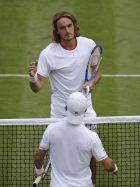 Italy's Thomas Fabbiano, back to camera, greets Stefanos Tsitsipas of Greece at the net after winning the Men's singles match during day one of the Wimbledon Tennis Championships in London, Monday, July 1, 2019. (AP Photo/Ben Curtis)