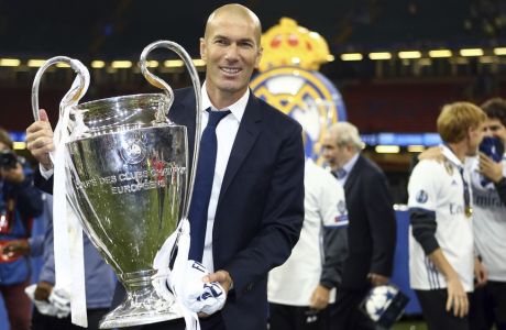 Real Madrid's head coach Zinedine Zidane celebrates with the trophy at the end of the Champions League soccer final between Juventus and Real Madrid at the Millennium Stadium in Cardiff, Wales, Saturday, June 3, 2017. Real won the match 4-1. (AP Photo/Dave Thompson)