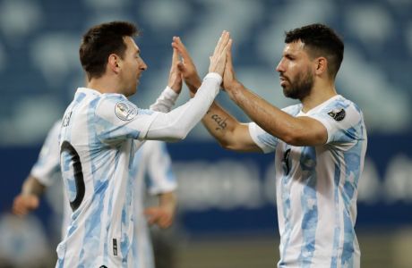 FILE - Argentina's Lionel Messi, left, celebrates scoring his side's second goal from the penalty spot with teammate Sergio Aguero during a Copa America soccer match against Bolivia at Arena Pantanal stadium in Cuiaba, Brazil, June 28, 2021. Barcelona striker Sergio Aguero has on Wednesday, Dec. 15 announced his immediate retirement for health reasons. (AP Photo/Bruna Prado, file)