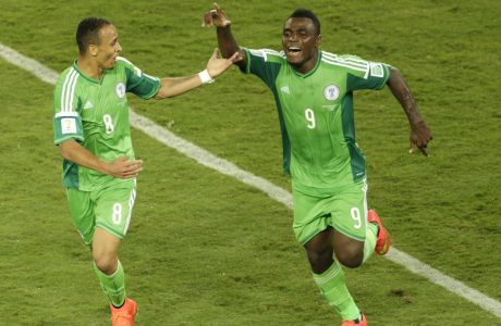 Nigeria's Peter Odemwingie, center, celebrates with his teammates Michael Babatunde, left, and Emmanuel Emenike after scoring the opening goal during the group F World Cup soccer match between Nigeria and Bosnia at the Arena Pantanal in Cuiaba, Brazil, Saturday, June 21, 2014. (AP Photo/Fernando Llano)
