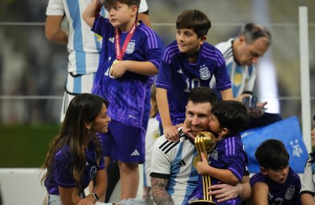 Argentina's Lionel Messi sits with his wife Antonella Roccuzzo after the World Cup final soccer match between Argentina and France at the Lusail Stadium in Lusail, Qatar, Sunday, Dec. 18, 2022. (AP Photo/Petr David Josek)