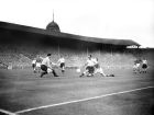 Harry Johnston, England is challenged by a Hungarian attacker as Gilbert Merrick the England goalkeeper waits to take the ball. Centre background is Jimmy Dickinson.