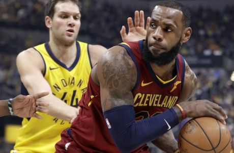 Cleveland Cavaliers' LeBron James, right, looks to pass as Indiana Pacers' Bojan Bogdanovic defends during the first half of Game 4 of a first-round NBA basketball playoff series, Sunday, April 22, 2018, in Indianapolis. (AP Photo/Darron Cummings)