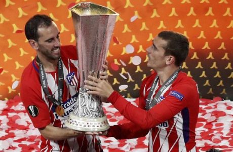 Atletico's Diego Godin, left, and Antoine Griezmann lift up the cup after the Europa League Final soccer match between Marseille and Atletico Madrid at the Stade de Lyon outside Lyon, France, Wednesday, May 16, 2018. Atletico Madrid won the Europa League for the third time with a resounding 3-0 victory. (AP Photo/Christophe Ena)