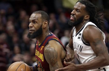 Cleveland Cavaliers' LeBron James, left, drives against Brooklyn Nets' DeMarre Carroll (9) in the second half of an NBA basketball game, Tuesday, Feb. 27, 2018, in Cleveland. (AP Photo/Tony Dejak)