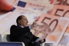 Italian former Prime Minister and Forza Italia (Go Italy) party leader, Silvio Berlusconi, backdropped by Euro banknotes gestures during the recording of the Italian state television RAI, Porta a Porta (Door To Door) talk show in Rome, Thursday, Jan. 11, 2018. (AP Photo/Andrew Medichini)