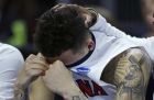 Arizona guard Gabe York hides his emotions as a teammate rests his hand on his head in the closing minute against Wichita State during the first round of the NCAA college men's basketball tournament in Providence, R.I., Thursday, March 17, 2016. Wichita State defeated Arizona 65-55. (AP Photo/Charles Krupa)