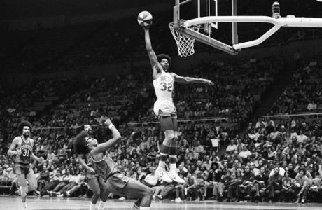 Julius Erving of the New York Nets, known as "Doctor J," scores during an ABA game at Nassau Coliseum, in Uniondale, N.Y.,  Nov. 29, 1975.  Virginia Squires' Mel Bennett backs away as Julius makes the score, and in background at left is Squires' Fatty Taylor.  Nets won, 116-97.  (AP Photo/Harry Harris)
