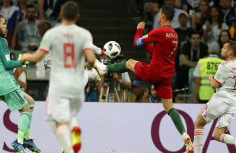 Portugal's Cristiano Ronaldo challenge for the ball in front of Spain goalkeeper David De Gea during the group B match between Portugal and Spain at the 2018 soccer World Cup in the Fisht Stadium in Sochi, Russia, Friday, June 15, 2018. (AP Photo/Frank Augstein)