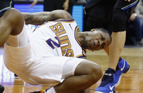 Phoenix Suns guard Isaiah Canaan injures his foot, landing awkwardly, after being fouled by the Dallas Mavericks during the first half of an NBA basketball game Wednesday, Jan. 31, 2018, in Phoenix. (AP Photo/Ross D. Franklin)