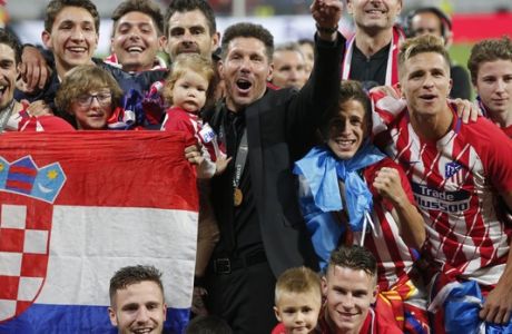Atletico's head coach Diego Simeone, in black suit, celebrates with his players after winning the Europa League Final soccer match between Marseille and Atletico Madrid at the Stade de Lyon in Decines, outside Lyon, France, Wednesday, May 16, 2018. (AP Photo/Thibault Camus)