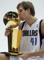 FILE - In this Dec. 13, 2011, file photo, Dallas Mavericks Dirk Nowitzki, of Germany, kisses the NBA championship basketball trophy during a photo shoot at the NBA basketball team's media day in Dallas. Now in his 20th season, Nowitzki is comfortable with the idea that he led the Mavericks to their first championship and can try to help a younger core build toward making Dallas a title contender again.  (AP Photo/LM Otero, File)
