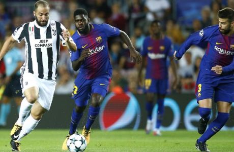 Juventus' Gonzalo Higuain fights for the ball against Barcelona's Samuel Umtiti during a group D Champions League soccer match between FC Barcelona and Juventus at the Camp Nou stadium in Barcelona, Spain, Tuesday, Sept. 12, 2017. (AP Photo/Manu Fernandez)