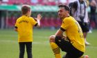 Dortmund's Mats Hummels celebrates with his son after the German Bundesliga soccer match between FC Augsburg and Borussia Dortmund at the WWK Arena in Augsburg, Germany, Sunday, May 21, 2023. (AP Photo/Matthias Schrader)