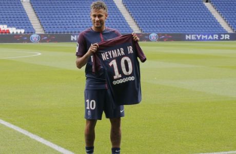 Brazilian soccer star Neymar holds his team shirt following a press conference in Paris Friday, Aug. 4, 2017. Neymar arrived in Paris on Friday the day after he became the most expensive player in soccer history when completing his blockbuster transfer to Paris Saint-Germain from Barcelona for 222 million euros ($262 million). (AP Photo/Michel Euler)