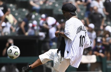 Soccer star Ronaldinho, of Brazil, kicks out a ceremonial first ball before a baseball game between the Chicago White Sox and the Cleveland Indians, Sunday, Aug. 1, 2021, in Chicago. (AP Photo/Matt Marton)
