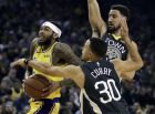 Los Angeles Lakers' Brandon Ingram, left, drives the ball past Golden State Warriors' Stephen Curry (30) and Klay Thompson in the first half of an NBA basketball game Saturday, Feb. 2, 2019, in Oakland, Calif. (AP Photo/Ben Margot)