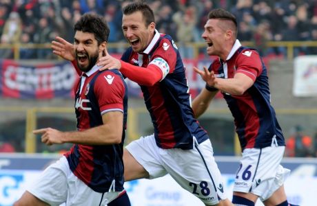 Bologna's Luca Rossettini, left, celebrates with teammates Daniele Gastaldello, and Anthony Mounier, right, after scoring during a Serie A soccer match between Bologna and Napoli, at the Bologna Dall'Ara stadium, Italy, Sunday, Dec. 6, 2015. (AP Photo/Gianfilippo Oggioni)