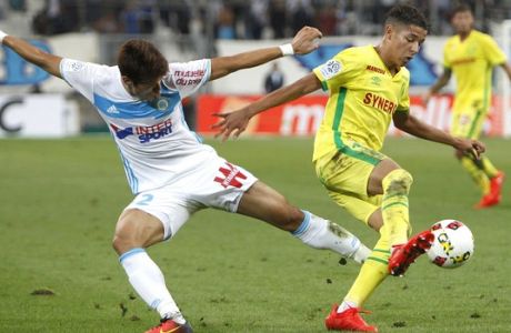 Marseille's defender Hiroki Sakai, left, challenges Nantes' defender Amine Harit for the ball during the League One soccer match between Marseille and Nantes, in Marseille, southern France, Sunday, Sept. 25, 2016. (AP Photo/Claude Paris)