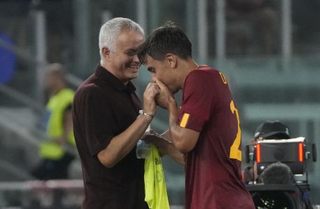 Roma's Paulo Dybala, right, greets coach Jose Mourinho during the Italian Serie A soccer match between Roma and Monza at Rome's Olympic Stadium, Tuesday, Aug. 30, 2022. (AP Photo/Gregorio Borgia)