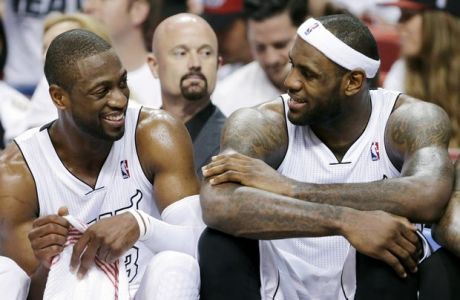 Miami Heat guard Dwyane Wade, left, and forward LeBron James laugh as they sit on the bench in the final seconds of Game 2 in their first-round NBA basketball playoff series against the Milwaukee Bucks, Tuesday, April 23, 2013 in Miami. Wade scored 21 points and James contributed 19 as the Heat won 98-86. (AP Photo/Wilfredo Lee)